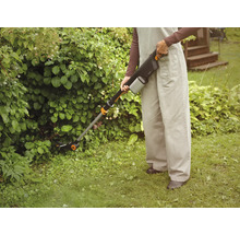 Person använder batteridriven grässax för trädgårdsarbete