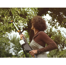 Kvinna använder en trädsåg för trädgårdsarbete.