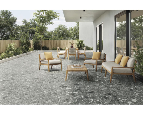 Uteplats med terrassplattor i stenlook, trädgårdsmöbler och växtlighet