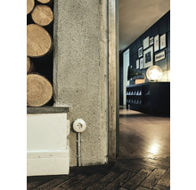 Närbild av ett rum med uttag, trävägg och trägolv