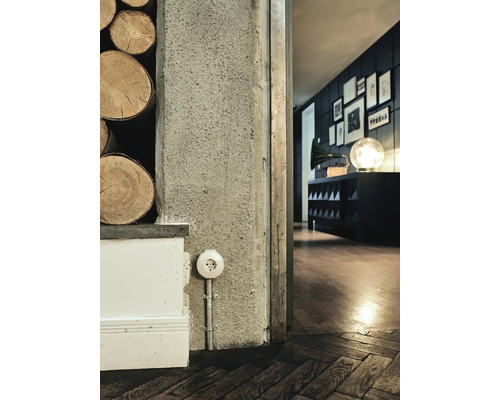 Närbild av ett rum med uttag, trävägg och trägolv