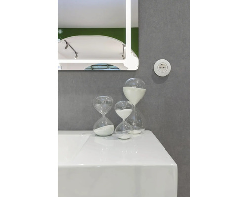 Tvättställ i badrum med spegel och timglas