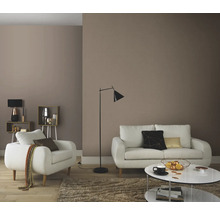 Vardagsrum med soffa, fåtölj, golvlampa och soffbord för en mysig atmosfär.