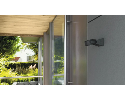 Utomhusstrålkastare på en husvägg med utsikt över trädgården