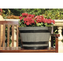 Blomkruka med röda begonier på en träbänk