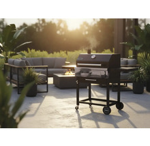 Trädgårdsscen med kolgrill, sittgrupp och eldstad för en mysig utomhusatmosfär.