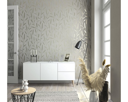 Ljust vardagsrum med tapet med bladmönster, skänk, golvlampa och dekoration