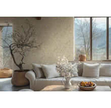 Vardagsrum med soffa, kuddar, bord, blomvas, krukväxt och blommig tapet för en mysig atmosfär