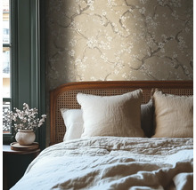 Sovrum med beige blommig tapet och säng med kuddar