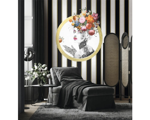 Elegant inrett vardagsrum med schäslong, rumsavdelare och konstverk på en randig vägg.