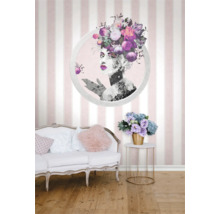 Dekorativt vardagsrum med randig tapet och blommotiv