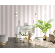 Vardagsrum med randig tapet, öppen spis, dekorativa bord och krukväxt