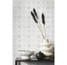 Närbild av en stilfull interiör med mönstrad tapet, en skål, en vas och dekorativa element på en hylla