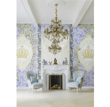 Vardagsrum med tapet, öppen spis, ljuskrona och fåtöljer