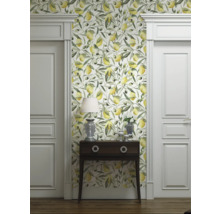 Rumsbild med tapet med citron- och olivmotiv, byrå, lampa och vita dörrar.