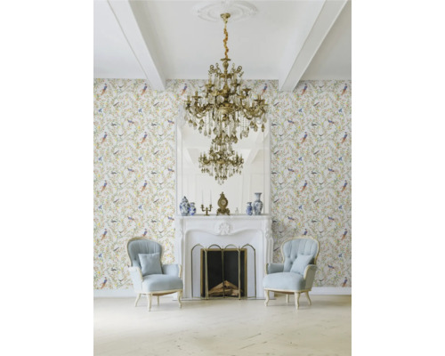 Klassiskt vardagsrum med tapet med fågelmönster, öppen spis, spegel och kristallkrona