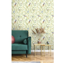 Rumsbild med grön sammetssoffa, gyllene sidobord och tapet med fågelmönster