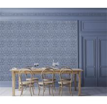 Matsal med utsmyckade tapeter, träbord och stolar.