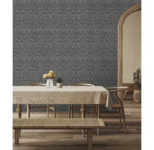 Dekorativt vardagsrum med mönstrad tapet bakom matbord och stolar.