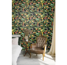 Sovrum med säng, fåtölj och väggbeklädnad med fruktmotiv.