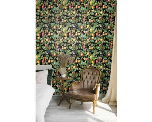 Sovrum med säng, fåtölj och väggbeklädnad med fruktmotiv.