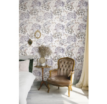 Dekorerat rum med säng, fåtölj, sidobord och blommig tapet