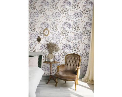 Dekorerat rum med säng, fåtölj, sidobord och blommig tapet