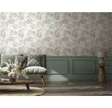 Vardagsrum med soffa, bord och vägg med blommig tapet