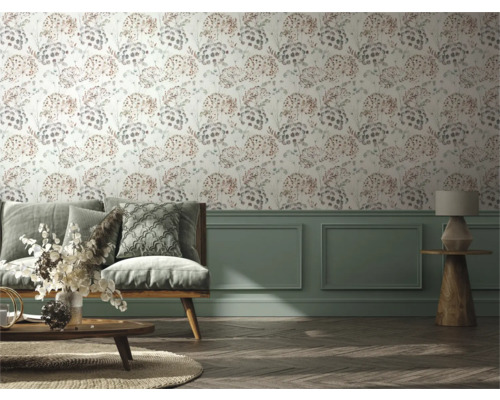 Vardagsrum med soffa, bord och vägg med blommig tapet