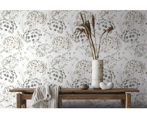 Dekorativ tapet med blommönster på vit bakgrund, tillsammans med ett träbord med dekorationer och en duk