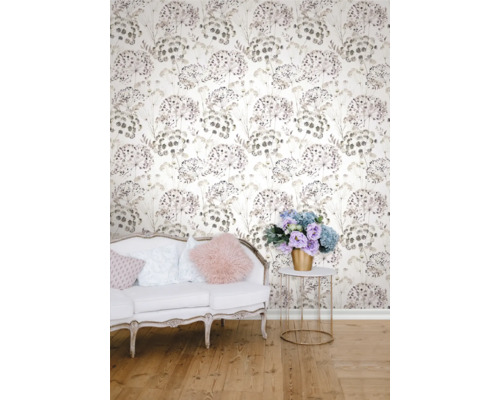 Dekorativt rum med en tapet med blommönster bakom en soffa och ett bord