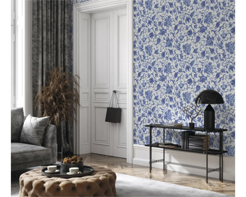 Vardagsrum med blommönstrad tapet, soffa, pall och dekorationer för en mysig atmosfär