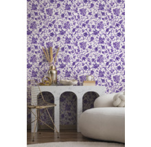 Rumsbild med tapet med blommönster i lila och vitt, bord med dekoration och stol.