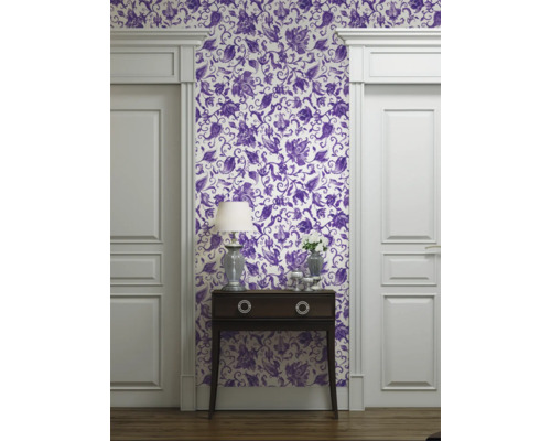Rumsöversikt med tapet med blommönster, byrå och dörrkarm