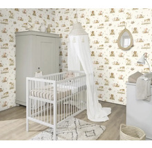 Barnrum med spjälsäng, skötbord och skåp framför en tapet med djurmotiv.