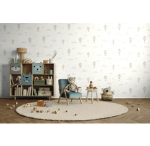 Barnrum med leksaksställ, fåtölj, bord och leksaker på en rund matta