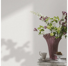 Dekorativ blomvas med blommor, kaffekopp och bakverk på ett sidobord