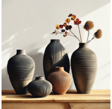 Grupp av räfflade vaser i olika storlekar och former på ett träbord, några med blommor.