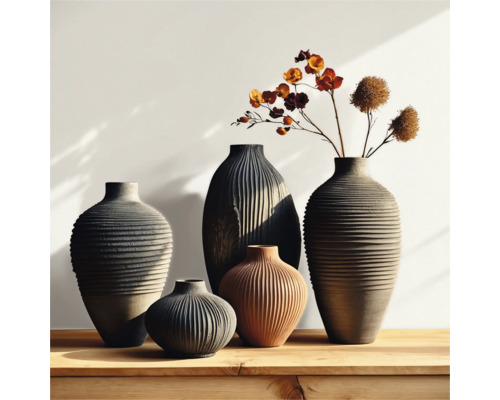 Grupp av räfflade vaser i olika storlekar och former på ett träbord, några med blommor.