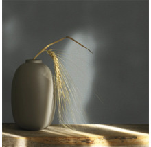 Dekorativ vas med spannmålsstrå på ett träbord