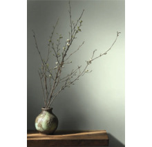 Dekorativa grenar med blommor i en vas på ett bord