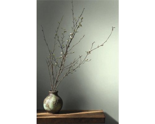 Dekorativa grenar med blommor i en vas på ett bord