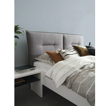 Sovrum med säng, vadderad sänggavel, kuddar och nattduksbord