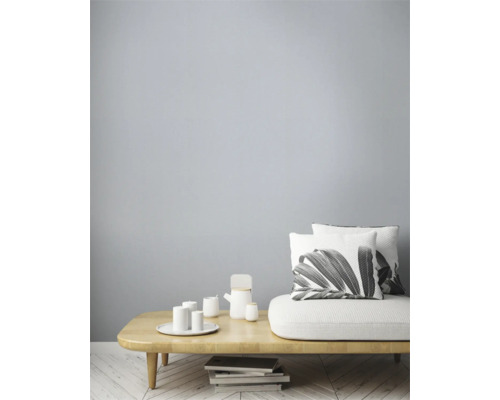 Ljust vardagsrum med soffa, kuddar, bord och porslin