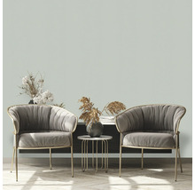 Två grå fåtöljer med ett sidobord och dekorativa element i ett vardagsrum