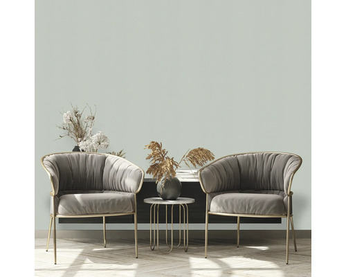 Två grå fåtöljer med ett sidobord och dekorativa element i ett vardagsrum