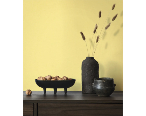 Dekorativ scen med skål på fötter fylld med valnötter, en vas med dekoration och en kruka på ett bord