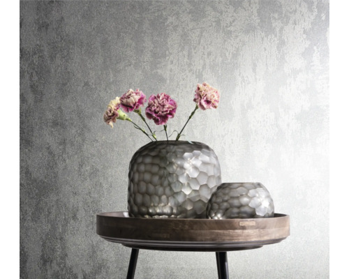 Dekorativa silverfärgade vaser med blommor på ett sidobord