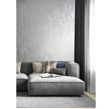 Vardagsrum med grå soffa, kuddar och mönstrad tapet