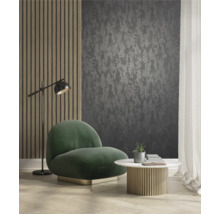 Vardagsrum med mörk mönstrad tapet, fåtölj, bord och golvlampa